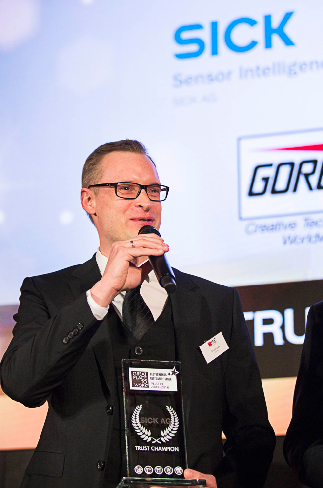 Jens Poppe, Leiter HR Consulting SICK AG, nimmt bei der Verleihungsgala in Berlin den Trust Champion Award in Platin entgegen. Foto: © Great Place to Work© Deutschland
