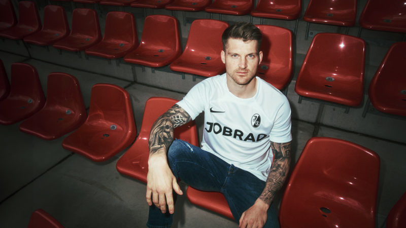 Abwehrspieler Lukas Kübler präsentiert eines der neuen Trikots.