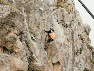 Felssicher und Sennebogen beim Arbeiten am Steilhang