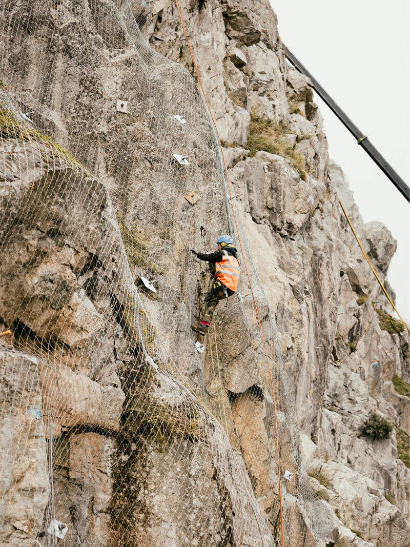 Felssicher und Sennebogen beim Arbeiten am Steilhang