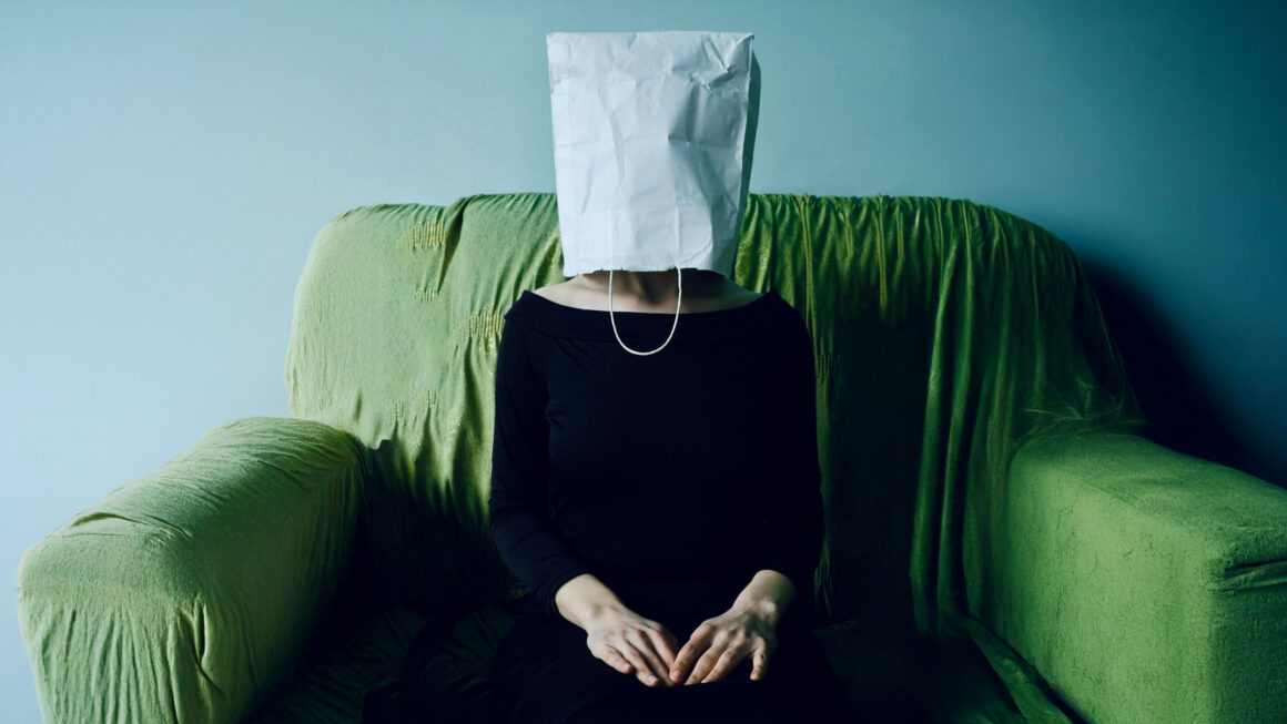 Frau mit Tuete ueberm Kopf