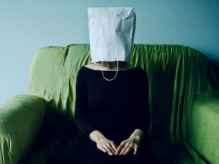 Frau mit Tuete ueberm Kopf