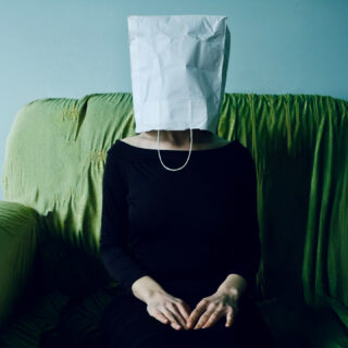 Frau mit Tuete ueberm Kopf